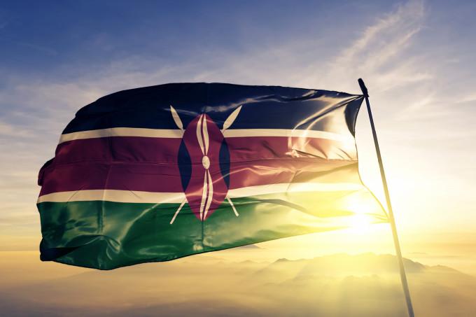 Kenya Kenyan flag on flagpole textile cloth fabric waving on the top sunrise mist fog